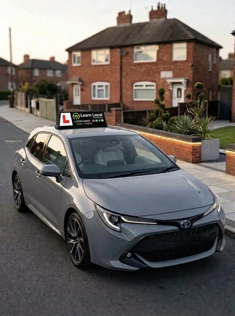 A Learn Local driving-school car with its roof sign parked on a Manchester residential street